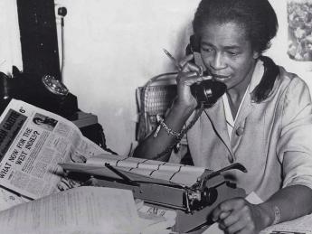 Black journalist Claudia Jones on the phone in the offices of the “West Indian Gazette” in London