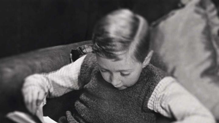 Photo of a young boy reading a book