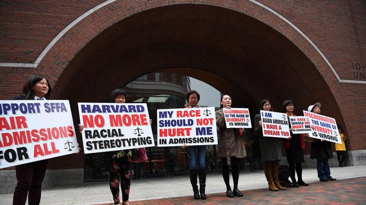 hotograph of demonstrators in front of the federal courthouse in Boston where the SFFA v. Harvard trial took place, with signs reading "Harvard No More Racial Stereotyping" and "My Race Should Not Hurt Me In Admissions.