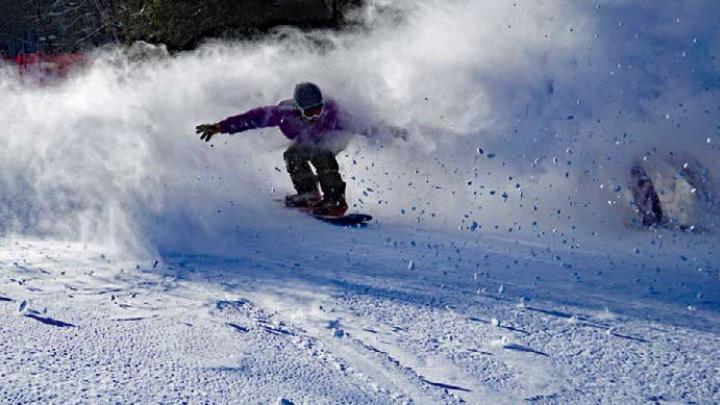 Skier coasting down the mountain with snow sprays